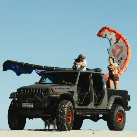 Véhicule 4x4 avec des kites sur les dunes