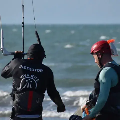 Instructeur et élève dans l'eau, vus de dos