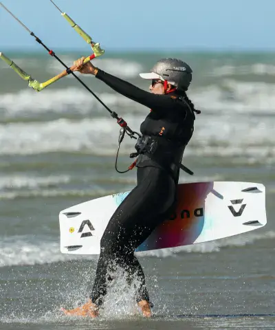 Kitesurfeur sortant de l'eau avec sa planche