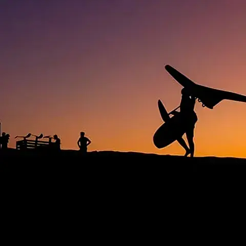 Wing foiler en silhouette au coucher du soleil
