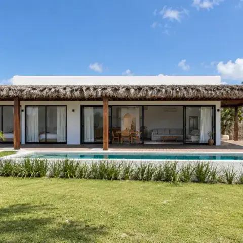 Façade d'une maison avec pelouse et piscine