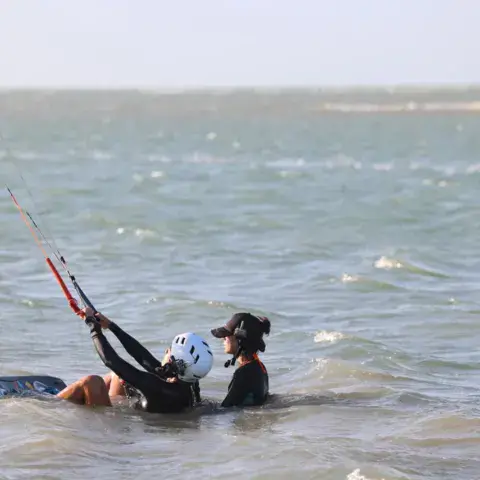 Élève avec son kite dans l'eau
