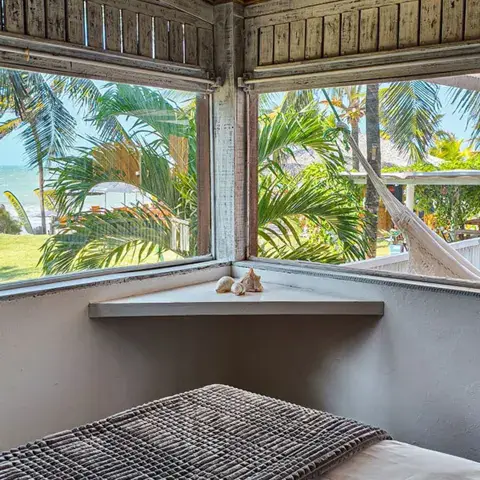 Chambre avec vue sur la mer à travers les cocotiers