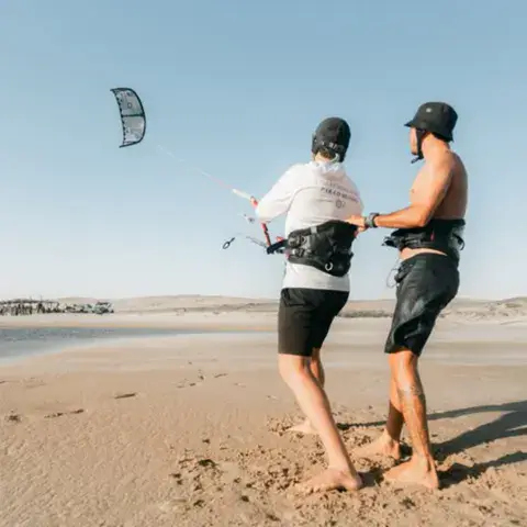 Briefing entre un moniteur et un élève sur la plage