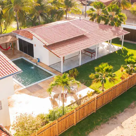 Vue aérienne d'une villa avec piscine entourée de palmiers