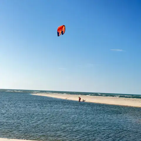 Kite dans le ciel au-dessus d'un plan d'eau et d'un banc de sable