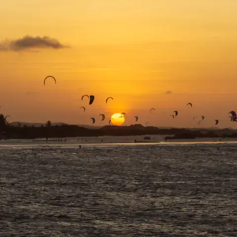 Kitesurfeurs sur l'eau au coucher du soleil
