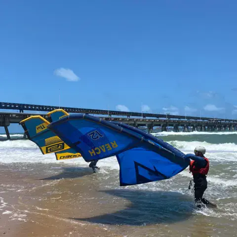 Aile de wing sur la plage près d'une jetée