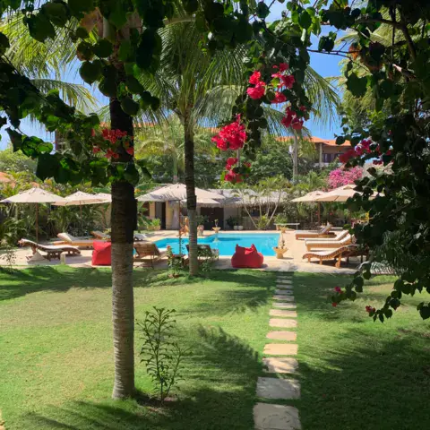 Allée de pierres dans le jardin, piscine au fond
