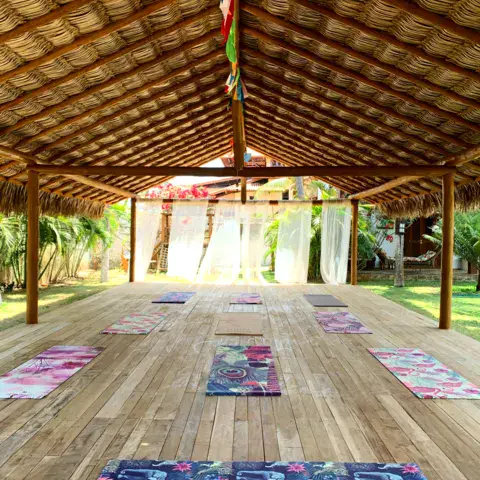 Plateforme de yoga en bois sous toit de palmes