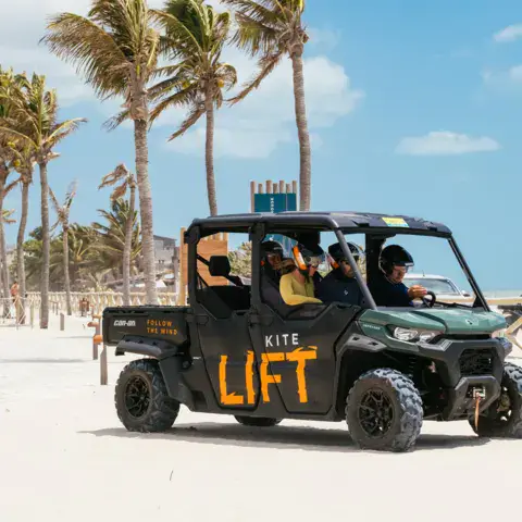 Véhicule « kite lift » transportant des kitesurfeurs sur la plage