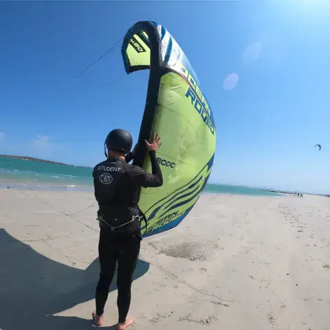 Rider qui prépare sa voile sur la plage