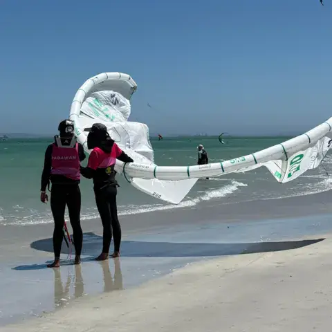 Élèves avec une voile au bord de l'eau