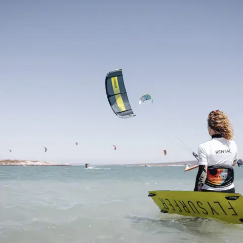 Rider prêt à partir sur le lagon, voile dans le ciel