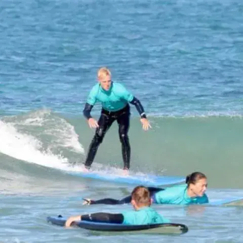 Élèves en cours de surf dans les vagues