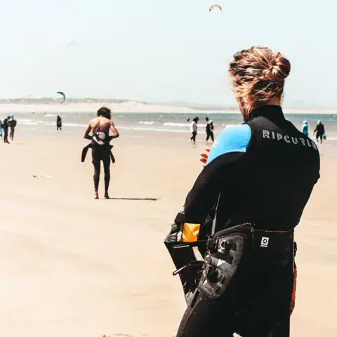 Kitesurfeur en combinaison sur la plage