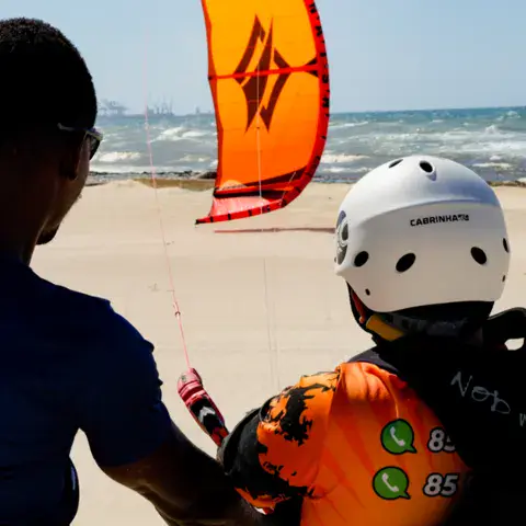 Moniteur et élève préparant le kite sur la plage