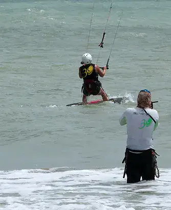 Élève de kitesurf en navigation, suivi depuis l'eau