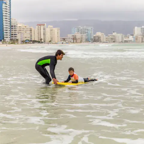 Moniteur et élève dans l'eau, face à la ville