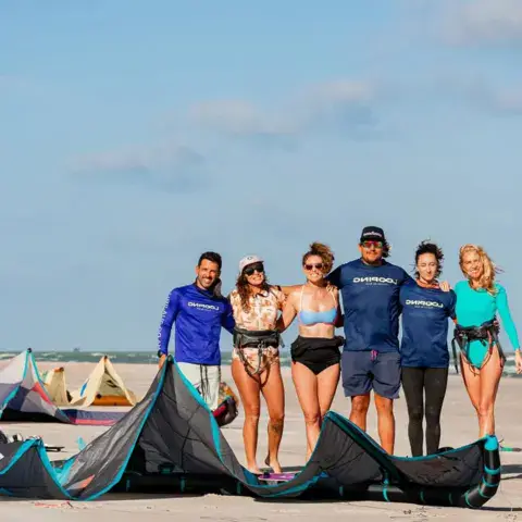 Équipe et élèves sur la plage avec les kites