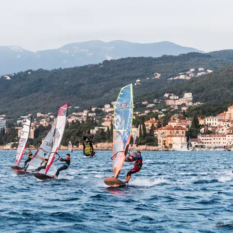 Windsurfeurs en course devant la côte