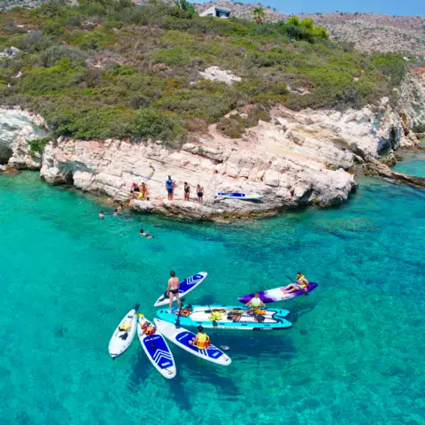 Groupe en stand up paddle dans une crique, vue aérienne