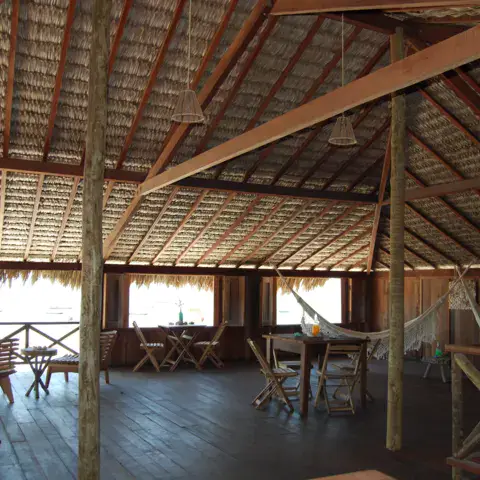 Salle commune à la charpente en bois et toit de chaume
