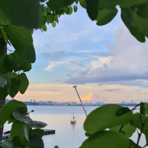 Plan d'eau avec un voilier au crépuscule