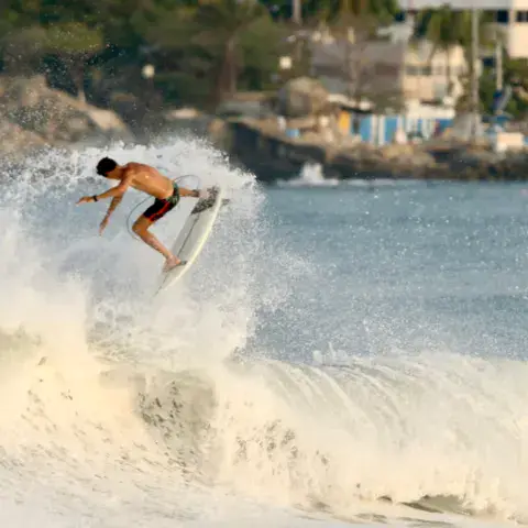 Surfeur en pleine manœuvre sur une vague