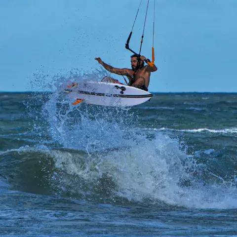 Kitesurfeur en saut au-dessus d'une vague