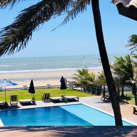 Piscine et plage bordée de palmiers