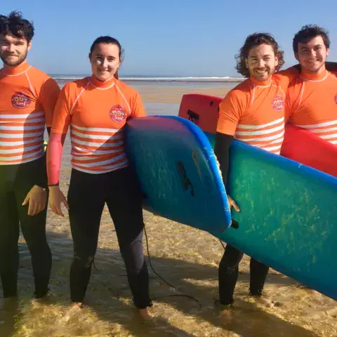 Équipe de moniteurs sur la plage avec les softboards