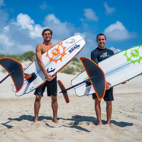 Deux riders avec leurs foilboards sur la plage
