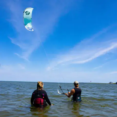 Moniteur et élève dans l'eau lors d'un cours de kitesurf