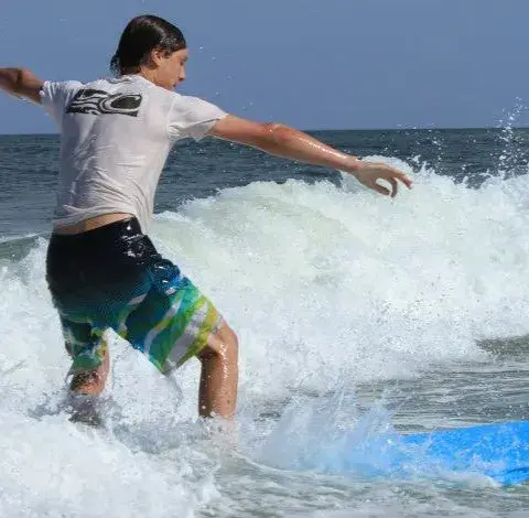Surfeur debout sur une planche dans l'écume