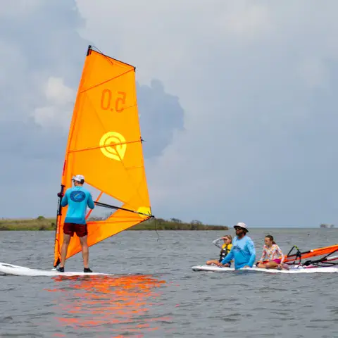 Cours de windsurf avec un groupe sur l'eau