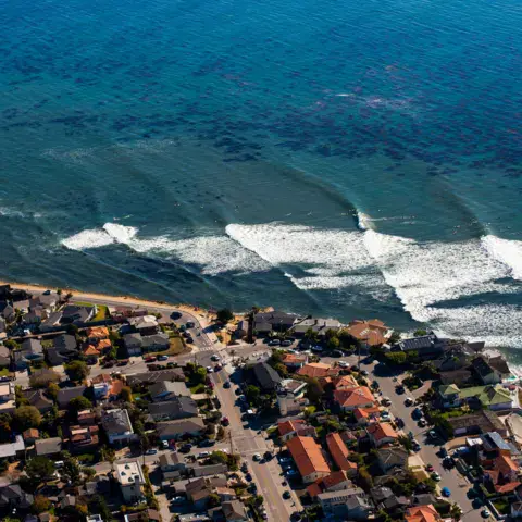 Vue aérienne d'un spot de surf au pied d'un quartier côtier