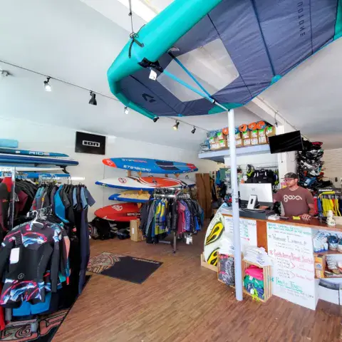 Intérieur de la boutique : combinaisons, planches et accessoires