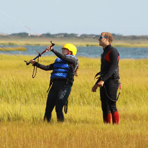 Exercice de pilotage d'aile avec un moniteur sur la berge