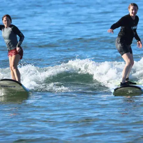 Deux surfeuses sur leur vague
