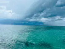 Eau turquoise peu profonde sous un ciel orageux