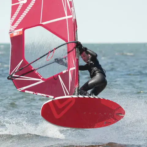 Windsurfeur en saut avec une voile rose