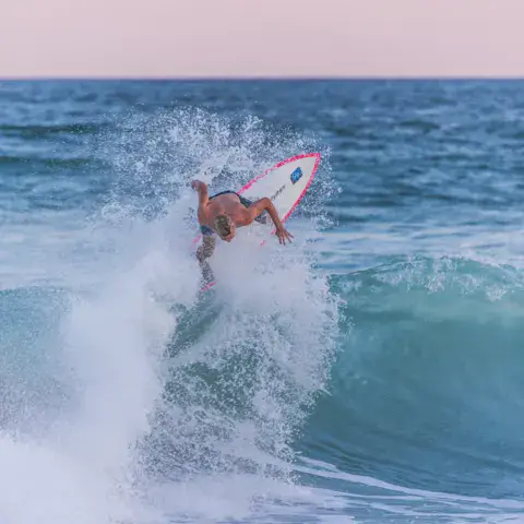 Surfeur en pleine manœuvre sur une vague