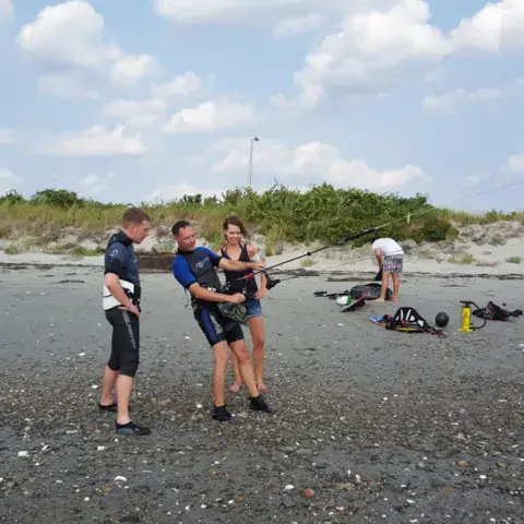 Groupe d'élèves avec un moniteur sur la plage