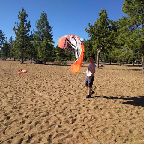 Élève avec un kite sur la plage