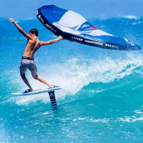 Rider en wing foil sur une vague