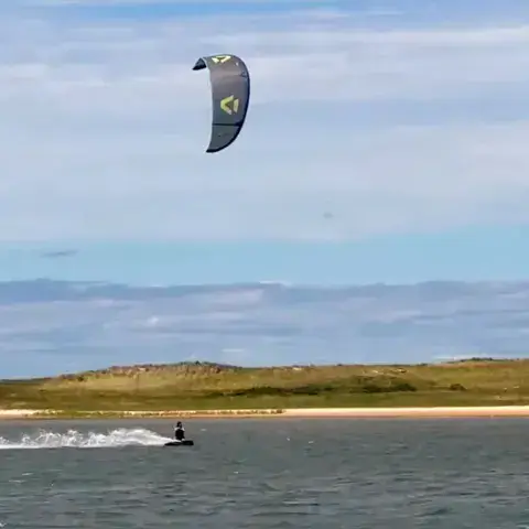 Kitesurfeur sur l'eau, aile dans le ciel