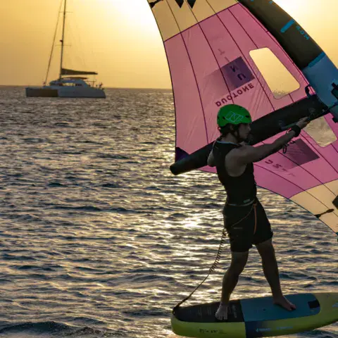 Rider de wing foil au coucher du soleil