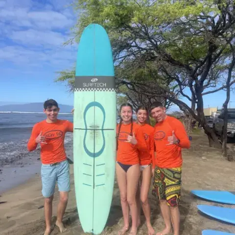 Équipe de moniteurs avec une planche sur la plage