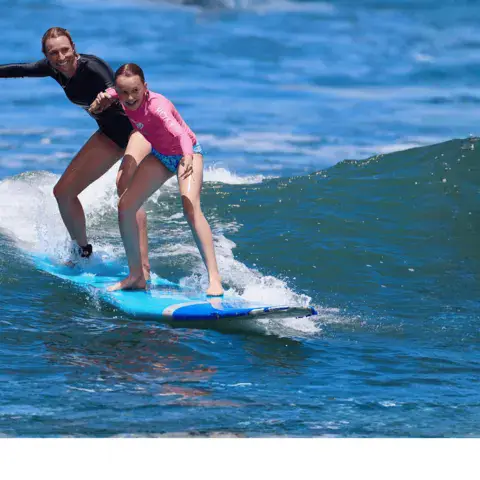 Cours de surf à deux sur une vague